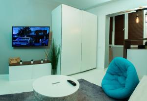 a living room with a blue chair and a tv at The Retreat in Sinaia