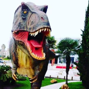 une statue d'un dinosaure avec sa bouche ouverte dans l'établissement Furnaka Eco Village, à Lourinhã