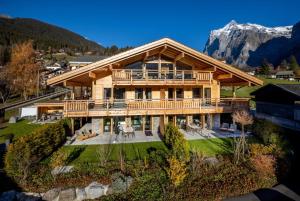 Chalet CARVE - Apartments EIGER, MOENCH and JUNGFRAU في جريندلفالد: اطلالة جوية على بيت فيه جبل