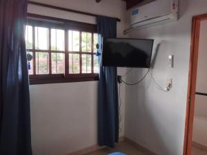 a room with a flat screen tv and a window at Las Hortensias in Junín