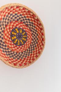 a woven basket with a red blue and yellow at Almograve Beach Hostel in Almograve