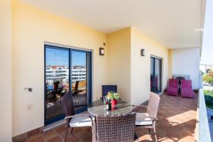 d'une terrasse avec une table et des chaises sur un balcon. dans l'établissement James's Quinta das Palmeiras, spacious 2 bedroom apartment in luxury complex, walking distance to town and beach, à Lagos