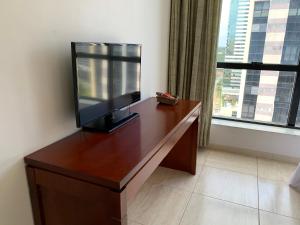 un escritorio de madera con TV encima en Flat Athenas 1402 en Salvador