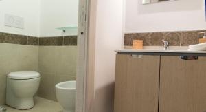 y baño con aseo y lavamanos. en Baglio Antico Forno, en Ustica