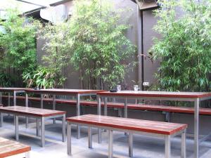 un grupo de mesas y bancos con plantas en Strathfield Hotel, en Sídney