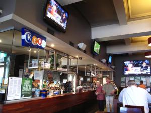 un bar in un ristorante con persone in piedi al bancone di Strathfield Hotel a Sydney