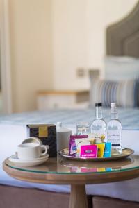 a table with a tray with bottles of alcohol and a plate with drinks at The Royal Duchy Hotel in Falmouth