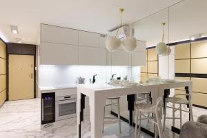 a kitchen with white counters and a white counter top at Super-Apartamenty VIP Jacuzzi in Poznań