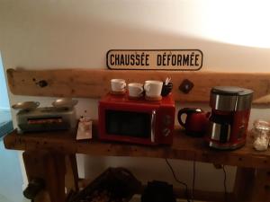 a table with a microwave and cups on top of it at Les Ronzières in Saint-Paul-dʼUzore