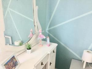 a room with a vanity with a mirror and dolls at Lelle-kert Apartman 02 in Balatonlelle +35 photos