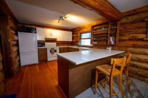 a kitchen with a counter and chairs in a cabin at Sitka Alpine Log Cabin in Whistler