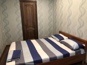 a bedroom with a bed with blue and white stripes at Prospect Polia apartment in Dnipro