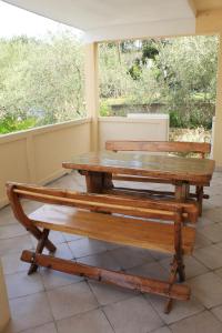 a wooden table and bench sitting on a porch at Apartments Kampor Damira in Rab