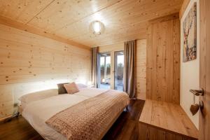 a bedroom with a bed in a wooden cabin at Chalet CARVE - Apartments EIGER, MOENCH and JUNGFRAU in Grindelwald