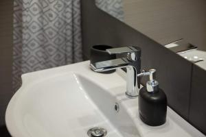 umywalkę w łazience z czarnym dozownikiem mydła w obiekcie Etoile apartment w mieście Perissa +30 zdjęć