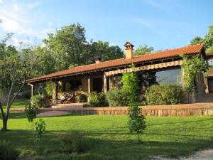 a house with a garden and a grass field at Hotel Rural El Camino in Candeleda