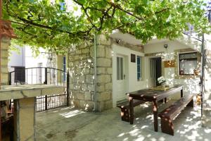 a patio with a wooden bench and a building at Melon-1, Murter, House for rest in Murter