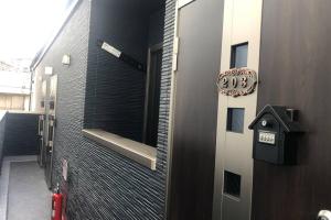 una porta con un cartello sul lato di un edificio di 玉藻本町203 a Takamatsu