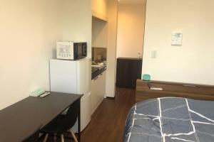 a small room with a kitchen with a white refrigerator at 玉藻本町203 in Takamatsu