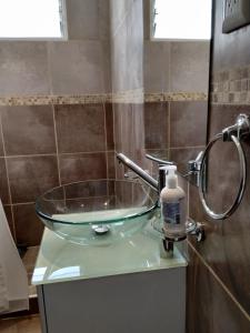 La salle de bains est pourvue d'un lavabo en verre et d'une douche. dans l'établissement Rincon de la Sierra, à Tandil
