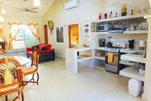 een keuken en een woonkamer met een fornuis en een bank bij Casa El Quinto Elemento, Departamento Fuego! in Isla Mujeres