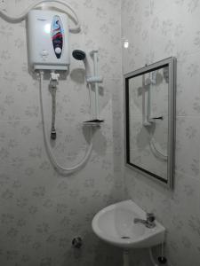 a bathroom with a sink and a hair dryer on the wall at Klebang Besar Townlodge in Melaka