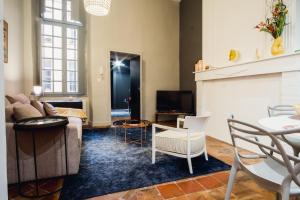 ein Wohnzimmer mit einem Sofa und einem Kamin in der Unterkunft room five - parking, balnéothérapie, place nationale, un havre de paix in Montauban
