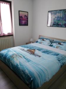a bedroom with a bed with a blue comforter at Tra le Vette in Caspoggio