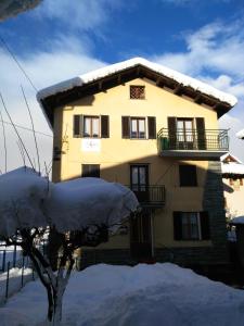 una casa con nieve en el suelo delante de ella en Tra le Vette en Caspoggio