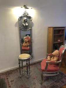 Habitación con espejo y 2 ositos de peluche en una silla en Mira Center Residence en Braşov
