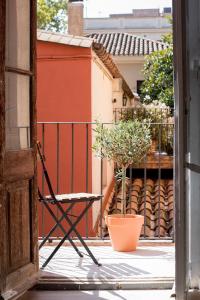 otwarte drzwi z krzesłem i doniczką w obiekcie CASA FILOMENA w Barcelonie