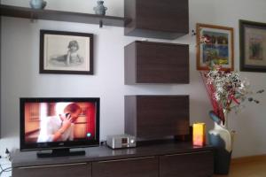 een woonkamer met een televisie op een tafel bij Bonito apartamento de 3 hab. con jardín in Roses