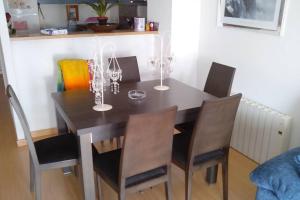 een eettafel en stoelen met wijnglazen erop bij Bonito apartamento de 3 hab. con jardín in Roses