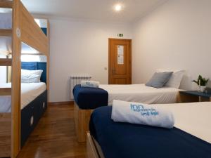 a room with two beds and a bunk bed at InnEsposende Sports Hostel in Esposende
