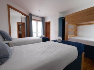 a hotel room with two beds and two windows at InnEsposende Sports Hostel in Esposende