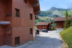 a building with a car parked in a parking lot at Grand-Bo: joli appartement sur les pistes avec vue in Le Grand-Bornand
