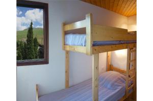 a bunk bed in a room with a window at Grand-Bo: joli appartement sur les pistes avec vue in Le Grand-Bornand