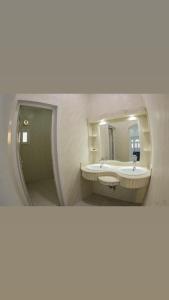 a bathroom with two sinks and a mirror at فلة ايكيا in Sohar