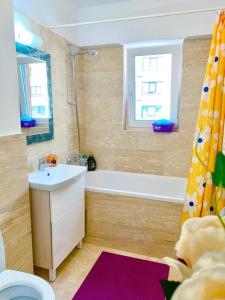 een badkamer met een wastafel en een bad bij Big & Cosy Apartment with 3 double beds by Evelyn Apartments in Iaşi