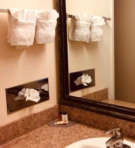 a bathroom with a mirror and a sink and towels at Arbor Inn Monterey in Monterey
