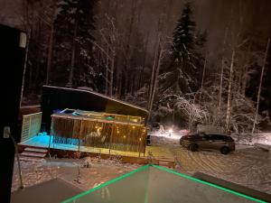a car parked in a snow covered yard at night at Tiny house in the middle of nature in Åkersberga