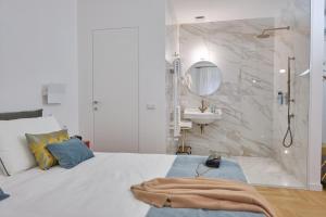 a white bedroom with a shower and a bed and a sink at Archè Design Rooms and Suites in Palermo +93 photos