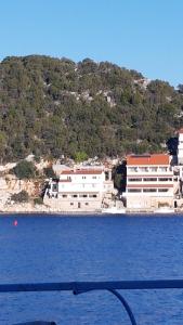 a group of buildings on a hill next to the water at Apartmani Lešić Zaklopatica in Lastovo