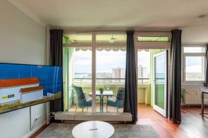 a living room with a large window and a table at Ferienwohnung Seaside in Schilksee