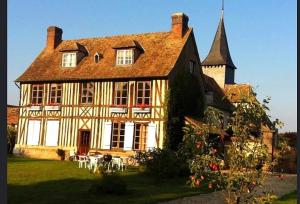 a large house with a church in a yard at Le petit Chapitre in Pinterville