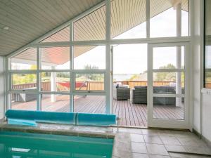 a screened in porch with a swimming pool and a patio at 8 person holiday home in Skals in Skals