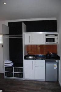 a kitchen with white cabinets and a microwave at Knysna Inn in Knysna