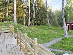 una pasarela de madera con una valla de madera en un bosque en 7 person holiday home in SKYLLBERG, en Skyllberg