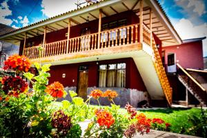 dom z balkonem i kwiatami przed nim w obiekcie Qali Samanawasi w mieście Huaro