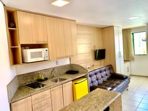 a kitchen with a sink and a microwave at Marulhos Resort Muro Alto Studio in Porto De Galinhas